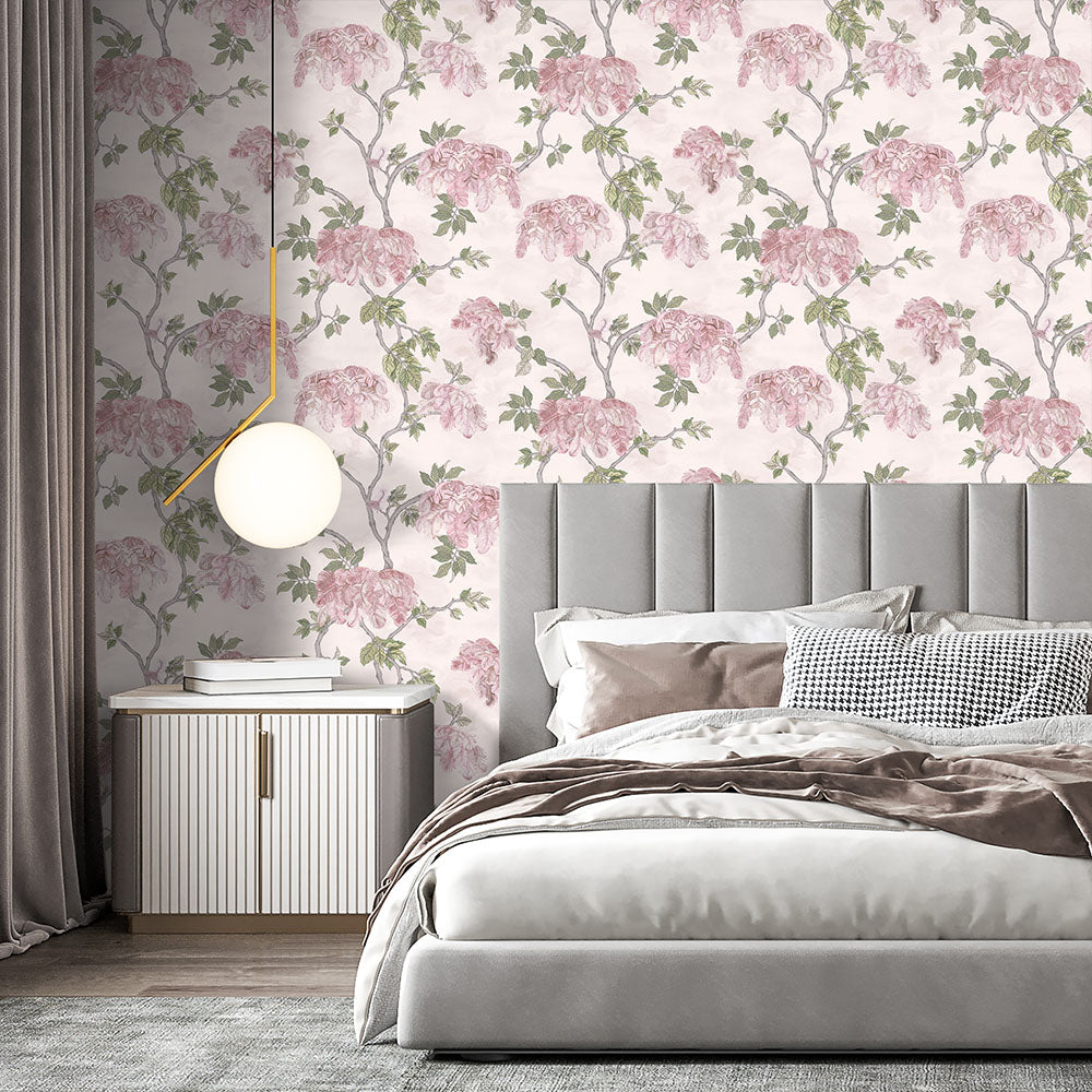 Soft pink floral Brand McKenzie Heart Deco wallpaper installed in a bedroom, showing pattern scale and color in a finished interior.