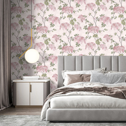 Soft pink floral Brand McKenzie Heart Deco wallpaper installed in a bedroom, showing pattern scale and color in a finished interior.